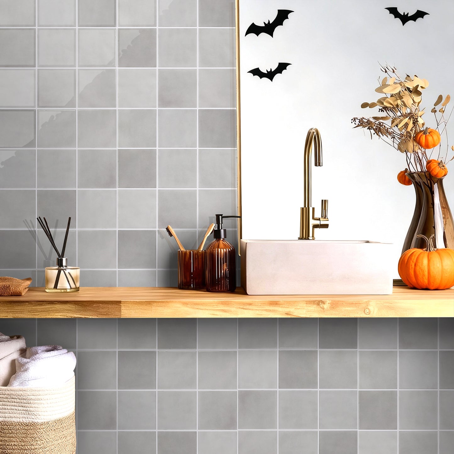 Bathroom with gray tiled walls, wooden countertop, and Halloween decorations.