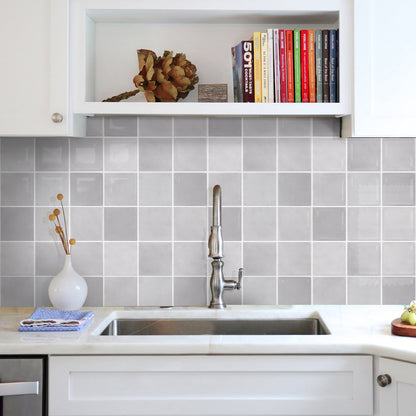 Kitchen with gray tiled backsplash, white cabinets, and a sink.