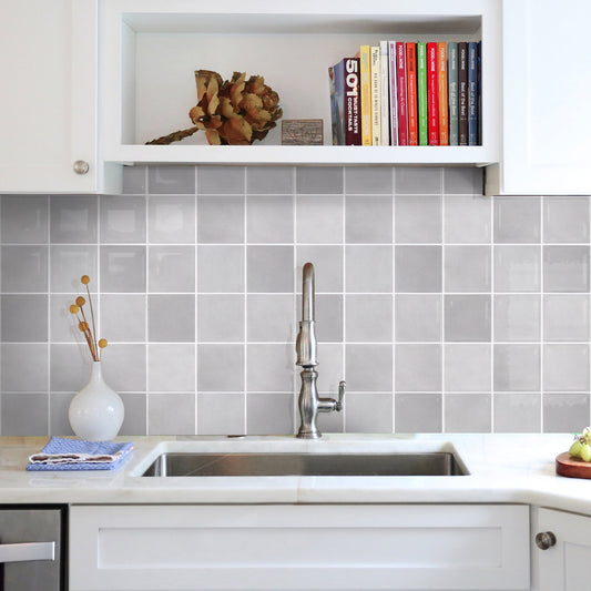 Kitchen with gray tiled backsplash, white cabinets, and a sink.