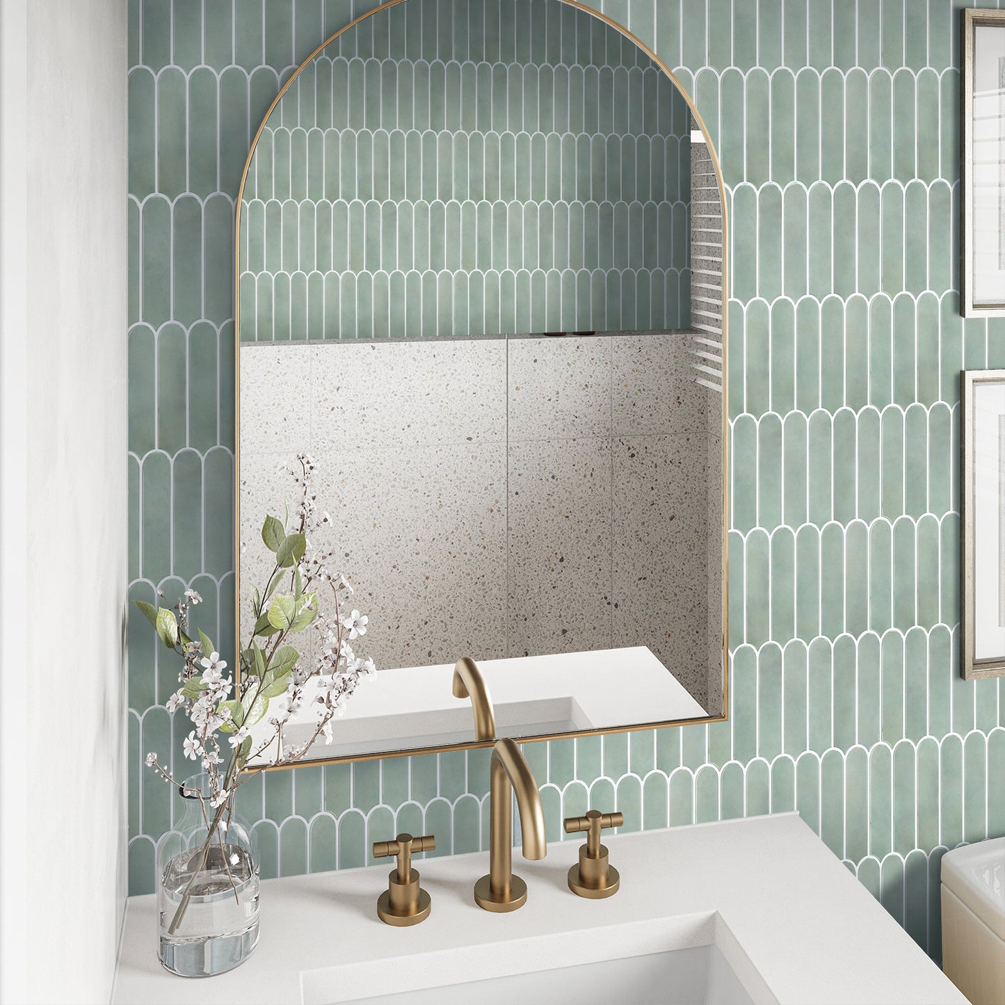 Bathroom with green tiled wall, white sink, and gold fixtures