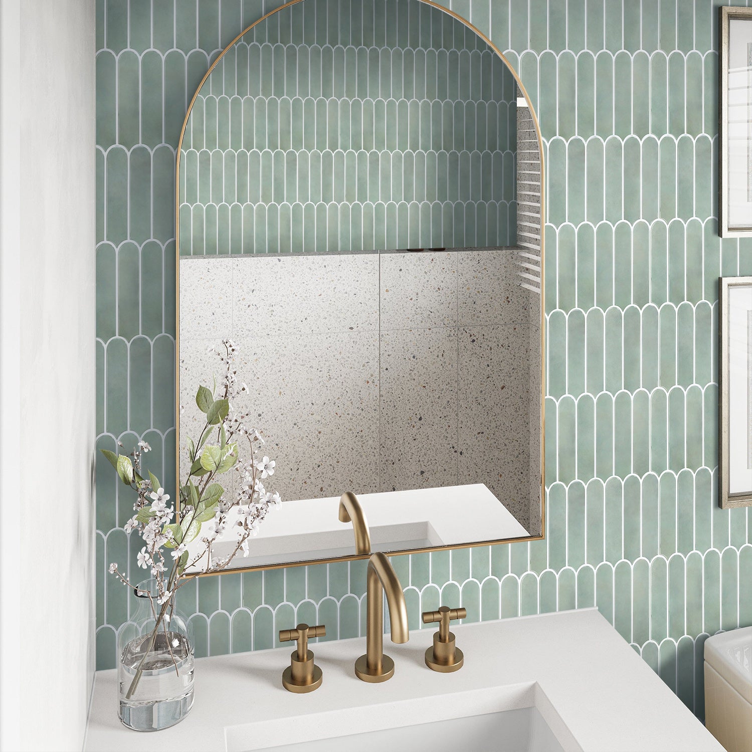 Bathroom with green tiled wall, white sink, and gold fixtures